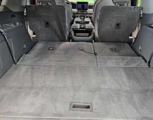 SUV interior with rear seats folded flat to create a large cargo area.