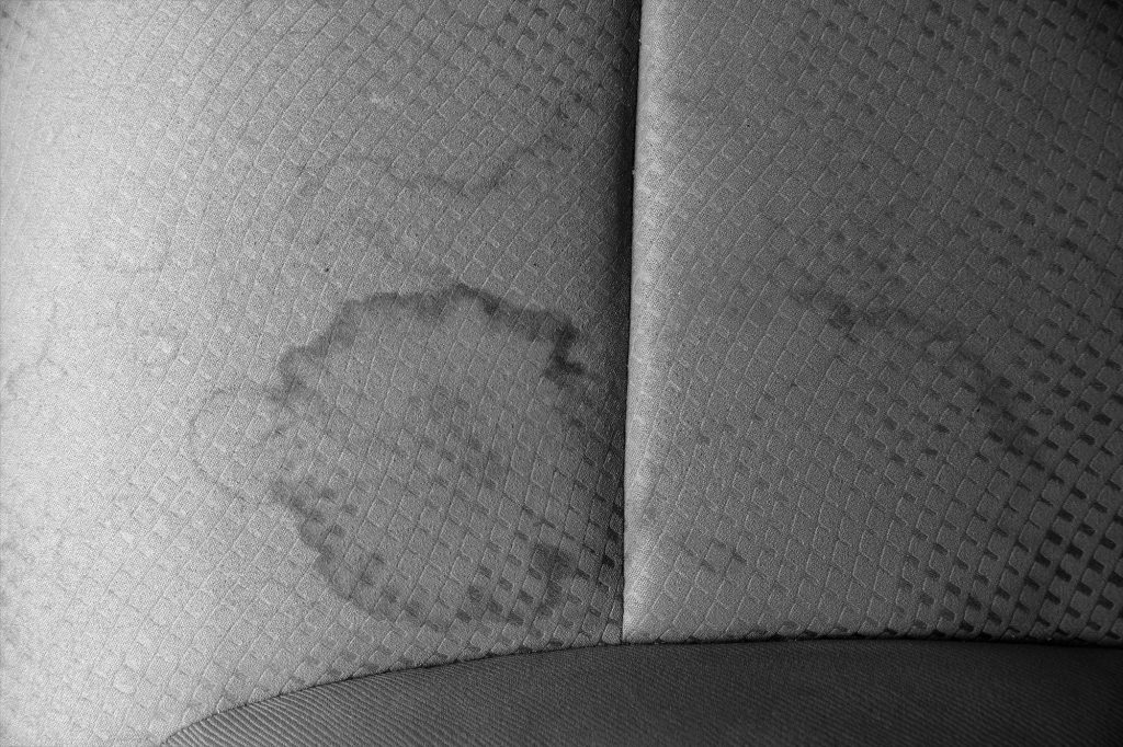 Close-up of gray car-seat fabric with a diamond-stitched quilt pattern and a vertical seam in the center panel.