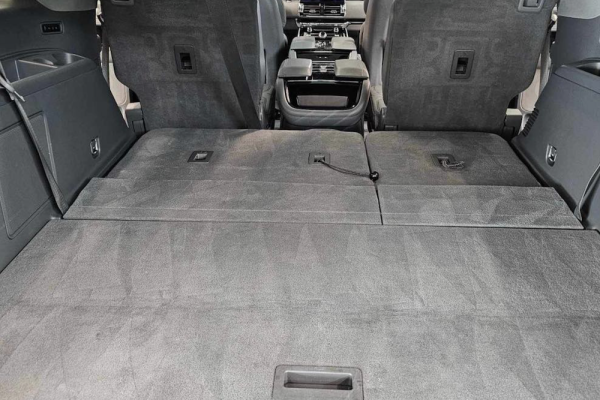 SUV interior with rear seats folded flat to create a large cargo area.